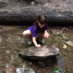BWNC girl in stream creating clay art