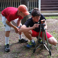 two boys set up a camera on a tripod