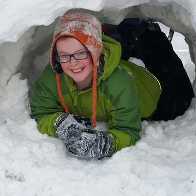 Program participant in a snow cave at Baltimore Woods.