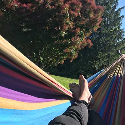 feet stretched out in a colorful hammock