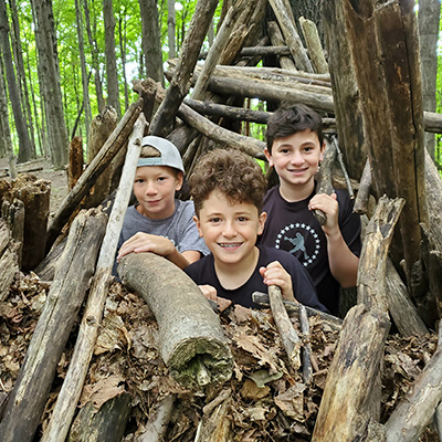 three boys in outdoor fort