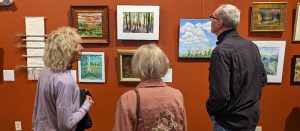 Visitors admiring the 2023 Members Art Show in the John A. Weeks Interpretive Center