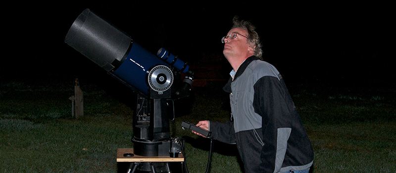 Observer using a telescope at night.