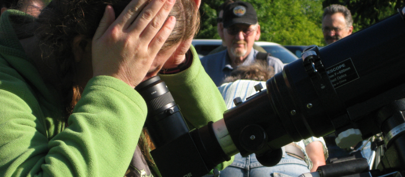 Sun Party attendee looking through a telescope