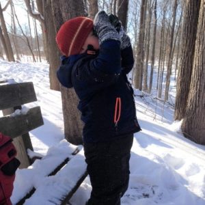 NLE participant using binoculars in winter.