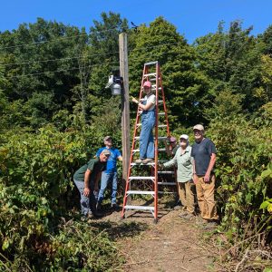 Volunteers and staff members install the new weather station at Baltimore Woods.