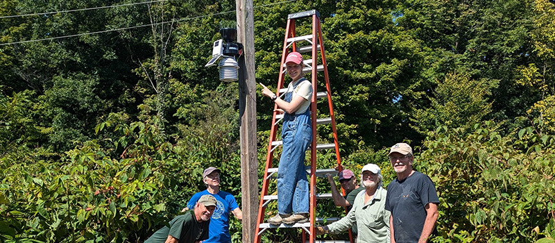 Volunteers and staff members install the new weather station at Baltimore Woods.