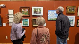 Visitors looking at an exhibit in the art gallery of the John A. Weeks Interpretive Center at Baltimore Woods Nature Center.