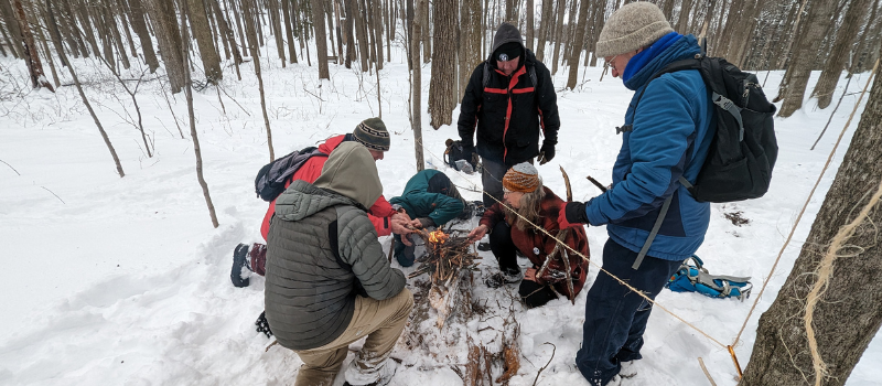Group of people making a fire in the snow